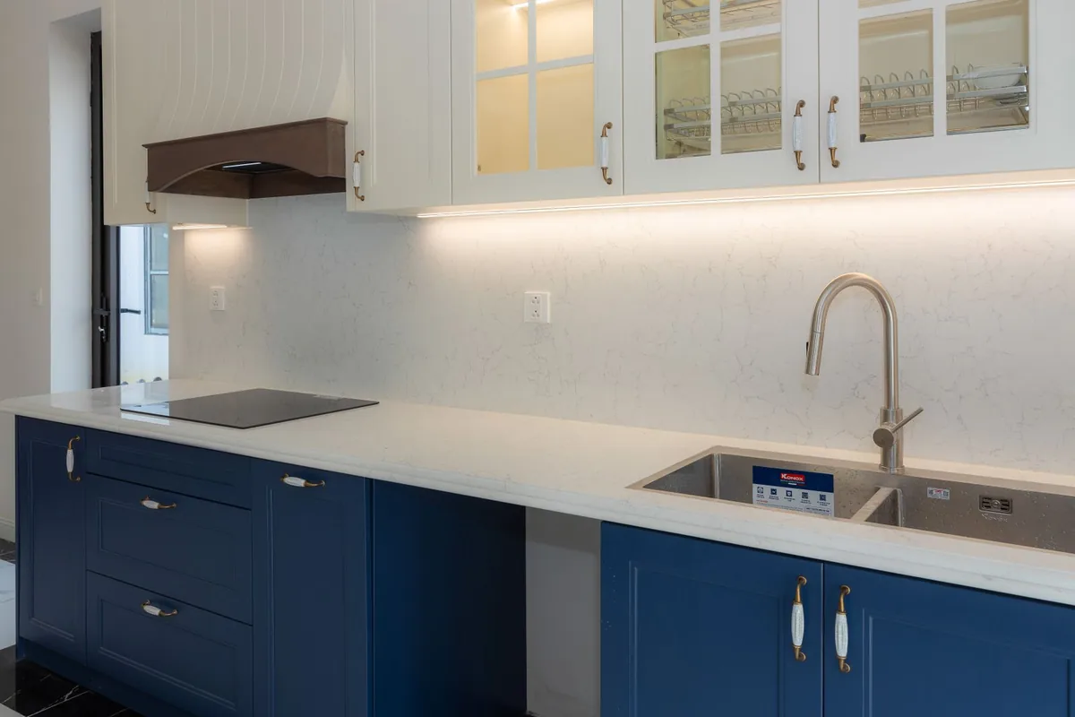 Navy panelled base cabinet doors and drawer fronts under a run of white glazed upper doors