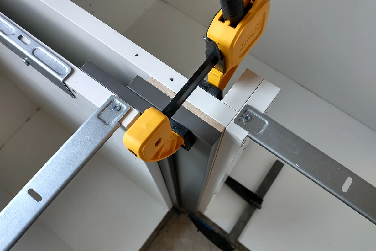A cabinet carcass being clamped and levelled during a fit in a Newport Beach CA bathroom