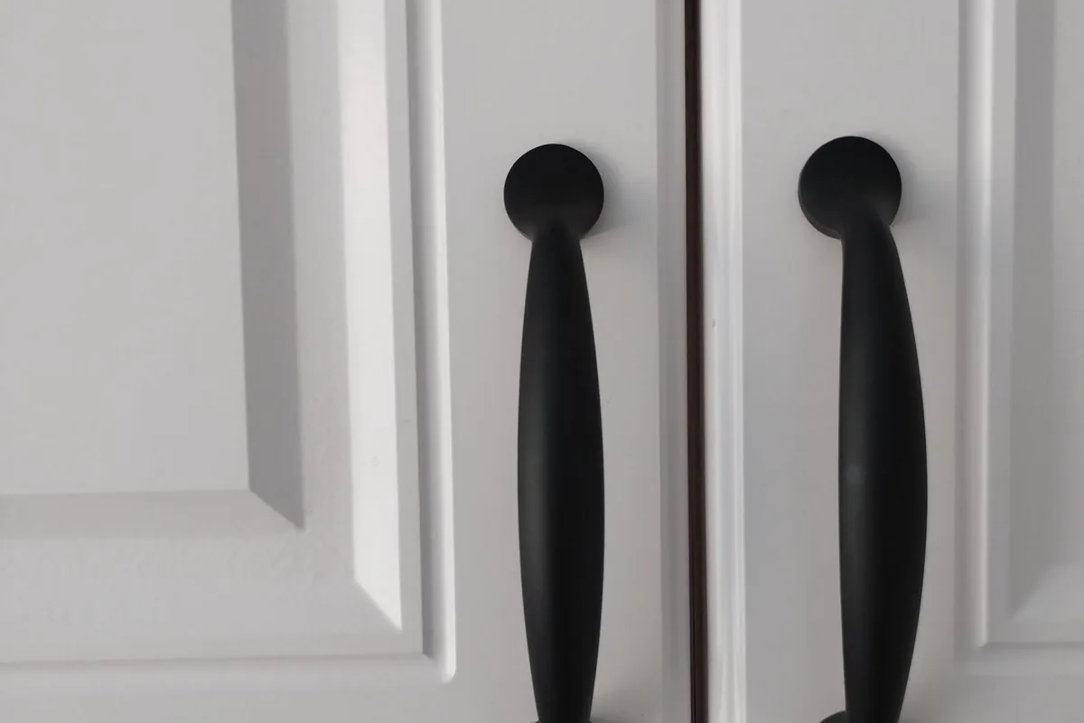 Close-up of black cabinet pulls on white painted cabinet doors in a Newport Beach CA kitchen
