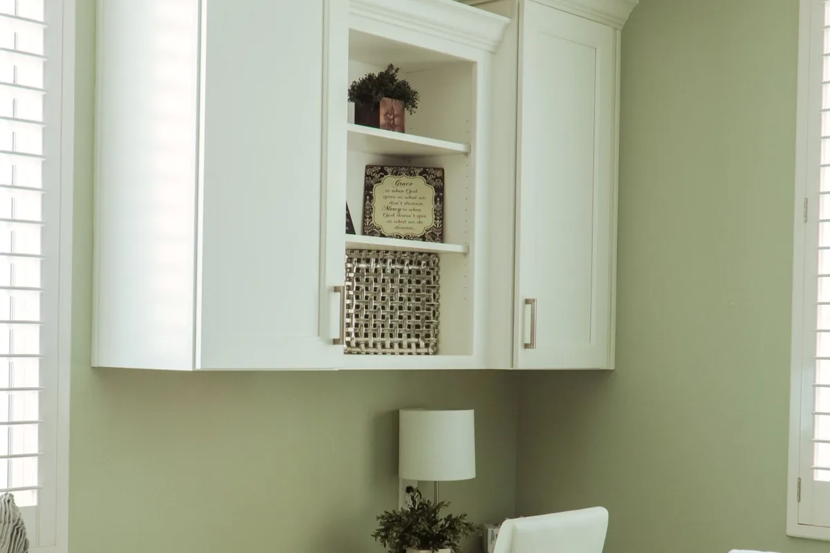 White built-in office cabinets with an open display bay above a desk area in a Newport Beach CA home
