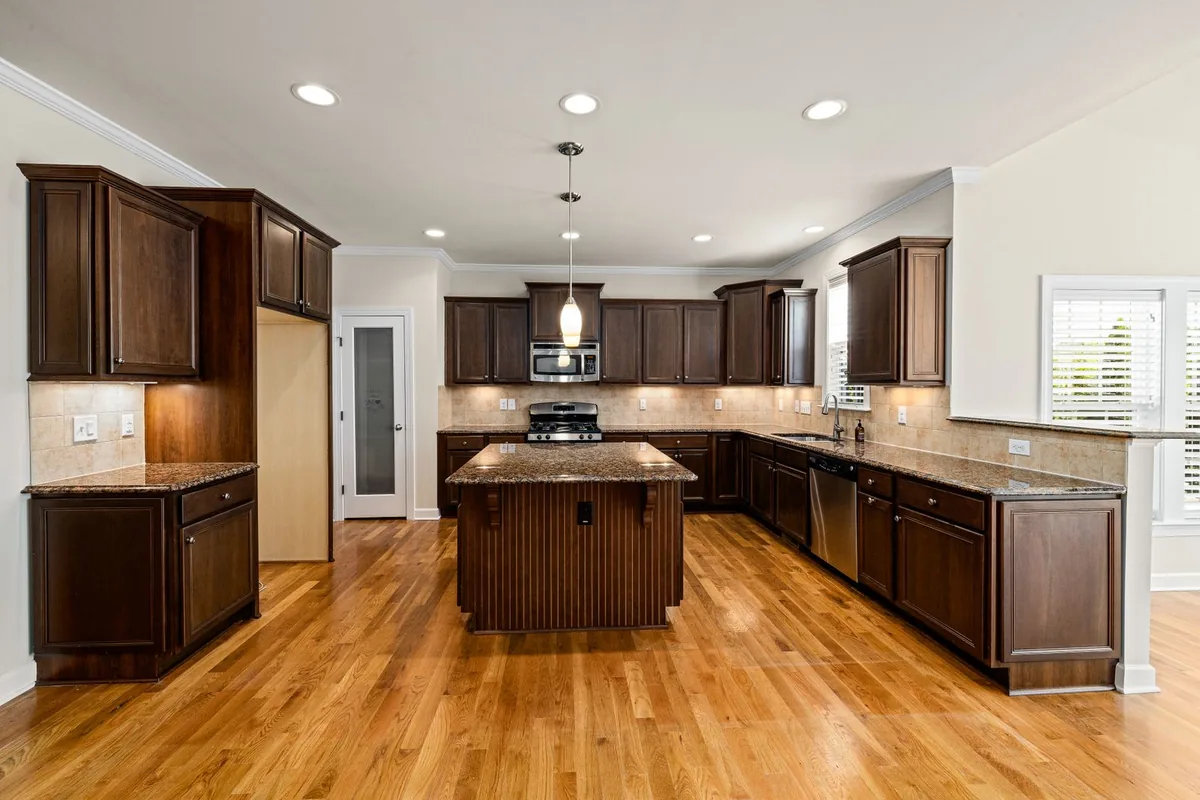 A run of stained custom kitchen cabinets with an island in a Newport Beach CA home