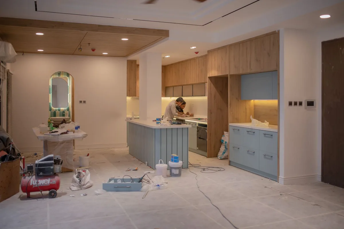 A room mid-renovation with cabinetry, tools and dust sheets in a Newport Beach CA home